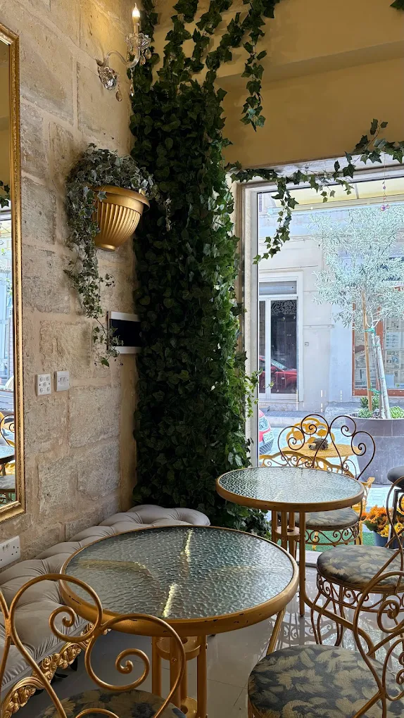 Serendipity Café interior with stone walls, plants and gold chairs